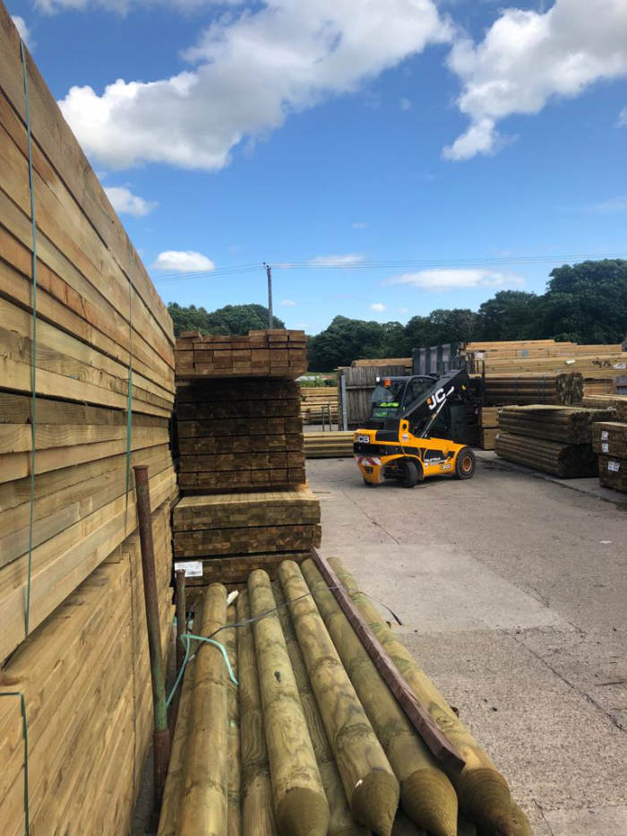 Forklift truck loading timber in Burtons timber yard